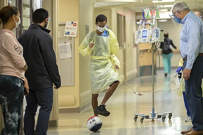 A few days after surgery, 在约翰霍普金斯儿童医院，威尔弗雷和他的护理团队正在走廊里传球.