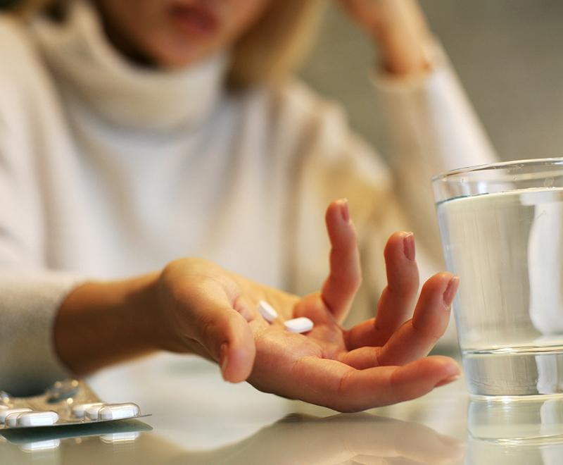 a frustrated woman holding pills